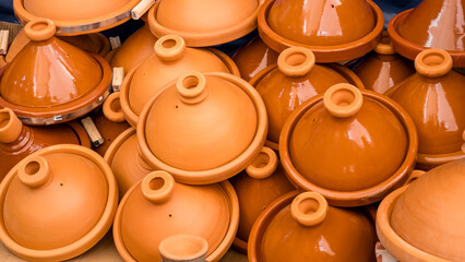 Many traditional ceramic tagine pots on market in Agadir, Morocco. Assortment of glazed and unglazed earthenware tajine pottery