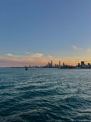 Fototapeta premium City Skyline By the Port at Sunset with Clear Peachy Skies and Rippled Water