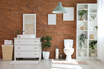 Interior of restroom with toilet bowl, sink and shelf unit