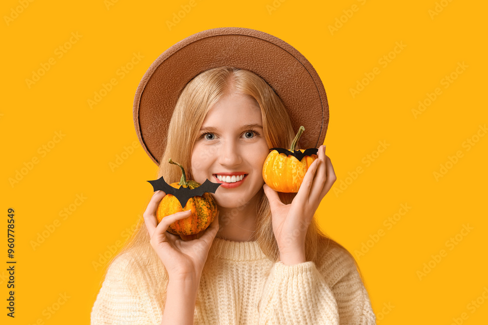 Canvas Prints beautiful young happy woman with halloween pumpkins and paper bats on yellow background