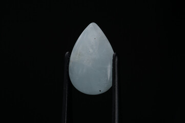 Elegant Teardrop Gemstone Captured in Gentle Light against a Dark Background