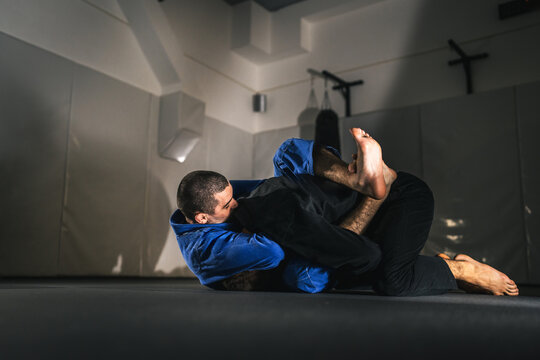 BJJ Brazilian Jiu jitsu Athlete fighters training sparing technique at the academy fight in gi kimono