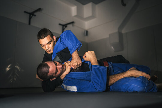 BJJ Brazilian Jiu jitsu Athlete fighters training sparing technique at the academy fight in gi kimono