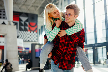 Travelers having piggyback ride at train station.