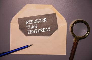 stronger than yesterday white chalk text on a vintage slate blackboard.