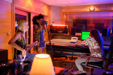 Multiracial music band recording a new song album in a music studio
