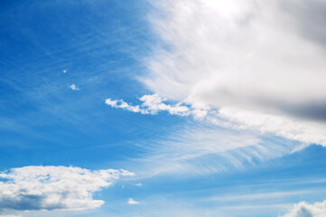 Vast blue sky landscape with white dramatic clouds, blue sky background, colorful blue sky with fluffy clouds lit by sunlight