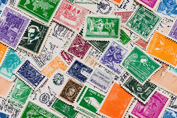 Fototapeta premium Seamless pattern of vintage postage stamps from around the world, slightly overlapping