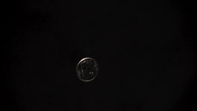US Quarter Flipping in Slow Motion on Black Background