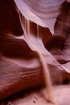 Wind and storms can blow sand into slot canyons creating a waterfall made of sand. Canyon X near Page, Arizona.