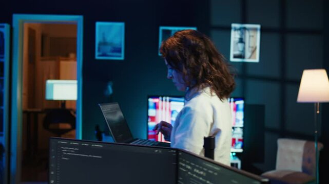 Developer doing software debugging using laptop, checking glitches in lines of code, upset about errors. Woman walking around home fixing coding issues using notebook device, camera B