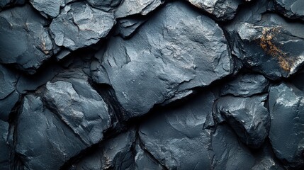 Close-up view of a textured, dark grey slate rock wall.