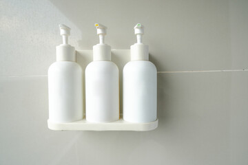 White bottle mockup for bathing products in bathroom, spa shampoo, shower gel, liquid soap hanging on the wall