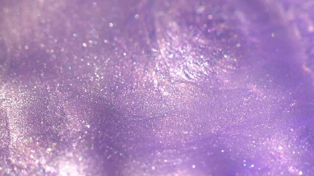 Pastel lilac color liquid pearls paint. Ink flow macro. Glitter fluid motion. Beautiful glitter abstract background