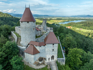 Fototapeta premium Aerial panoramic view of Zovnek castle, oldest medieval stronghold in Slovenia with partially restored great tower, castle gate, draw bridge