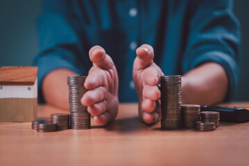 Divorce law and inheritance separation concept. Hand separate saving money, finance, home loan, debt return and inherit division. Bank business investment. Man separate stack coin, wood house on desk