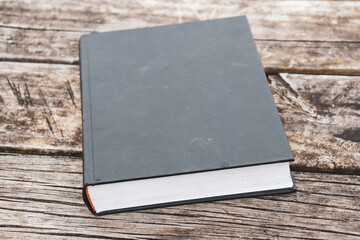 Fototapeta premium old hardcover book on outdoor wooden table