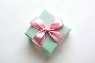 A mint green gift box with a pink ribbon on white background captured from above