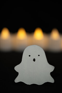 un fantasma hecho de papel con fondo de velas encendidas 
