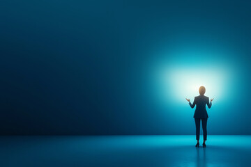 Obraz premium A professional figure stands in a spotlight, embodying confidence and determination in a serene blue environment.
