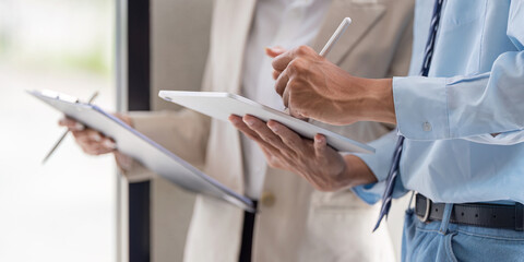 Close-up of business document and tablet interaction