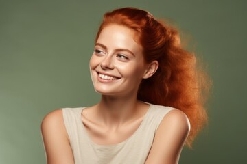 Young woman with green eye patches on her face, isolated against a beige background. Close-up portrait of a ginger-haired girl wearing a T-shirt and looking away while smiling, applying a cosmetic gel - Powered by Adobe