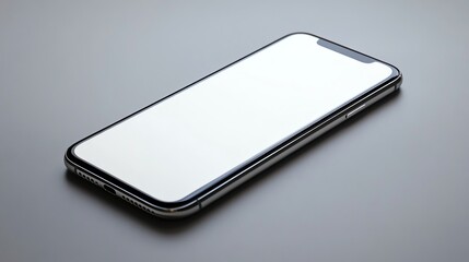 A silver smartphone with a blank white screen lying on a grey surface.