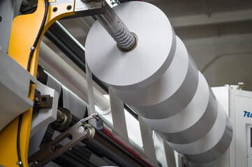 The process of winding paper self-adhesive tape into rollers of printing offer paper for printing...