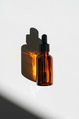 Aromatic Essential Oil Bottle With Dropper on White Surface in Bright Natural Light