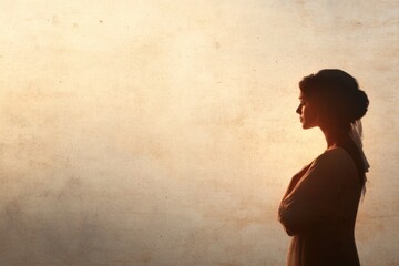 Silhouette of a Modestly Dressed Woman Against Soft, Textured Background in Warm Light