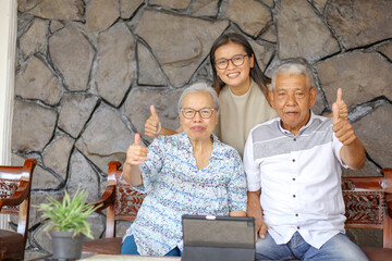 Asian Old Parents and Adult Daughter Showing Thumbs Up While Sitting on Terrace Sofa