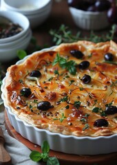 Pissaladiere A savory Pissaladiere tart with caramelized onions, anchovies, and olives on a thin, crispy crust