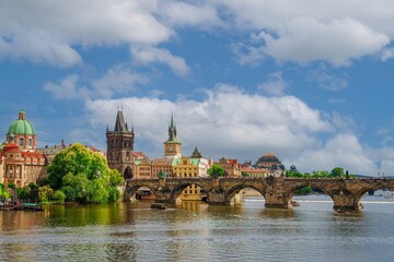 Beautiful cityscape image of Charles Bridge and Prague Castle with blue sky and white clouds in background, Czech Republic, Europe. Famous travel destination and touristic attraction of Czech Republic