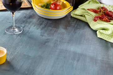 Rustic Dining Table with Wine, Peppers, and Dishes on a Dark Textured Surface