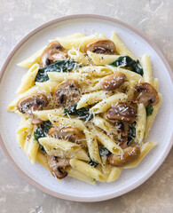 Penne pasta with mushrooms, spinach and cheese. Healthy food. Vegetarian food.