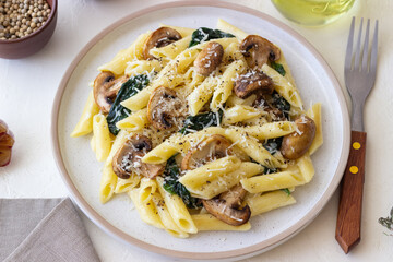 Penne pasta with mushrooms, spinach and cheese. Healthy food. Vegetarian food.