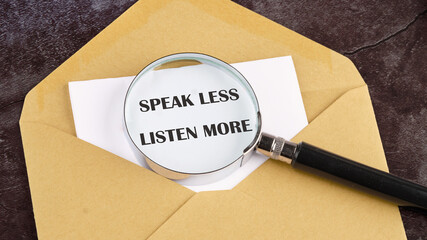 Speak less listen more symbol. Concept words Speak less listen more through a magnifying glass in a letter on white paper sticking out of an envelope