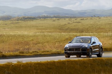 Fototapeta premium Black expensive SUV journey through countryside