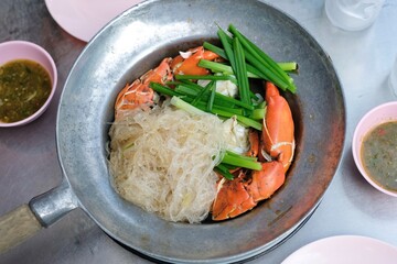Steamed mud crab with glass noodles, green onions and chives served with nam jim jaew (seafood dipping sauce) at Somsak Pu Ob (Charoen Rat) a street food cart in Khlong San - Bangkok, Thailand