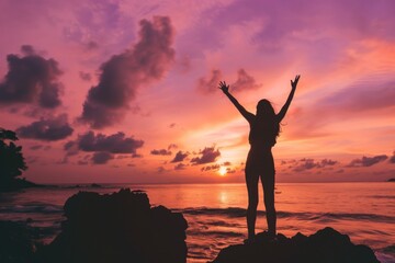 Fototapeta premium A joyful moment of celebration during a breathtaking sunset by the ocean, embodying happiness and freedom in nature's embrace