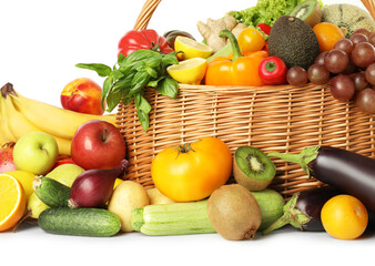 Many different fruits and vegetables in wicker basket isolated on white