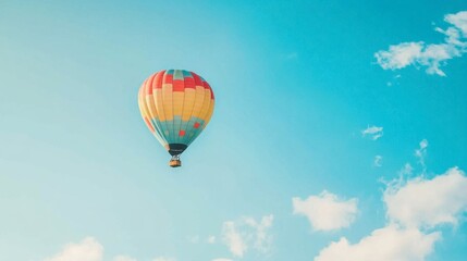 Fototapeta premium A clear blue sky with a colorful hot air balloon floating peacefully, capturing the essence of adventure.