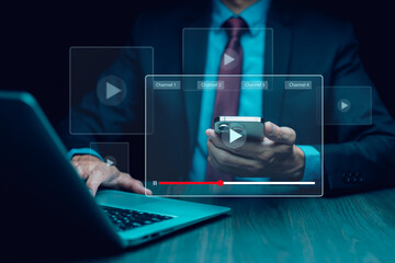 A person is pointing at a screen with a video playing. The screen is lit up and has a blue background. streaming online, watching video on internet education on internet and e-learning concept.