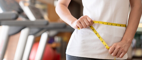 Diet and dieting. Beauty slim female body use tape measure. Woman in exercise clothes achieves weight loss goal for healthy life, crazy about thinness, thin waist, nutritionist.