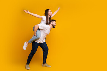 Full size photo of pretty young male female piggyback flying raise hands wear trendy white outfit...