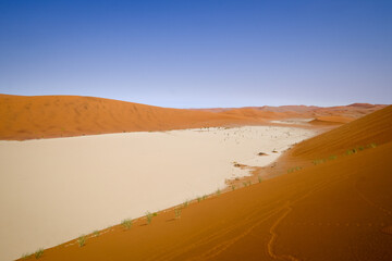 Panoramic view of the expansive sand dunes and dry white clay pans of Deadvlei, Namibia.