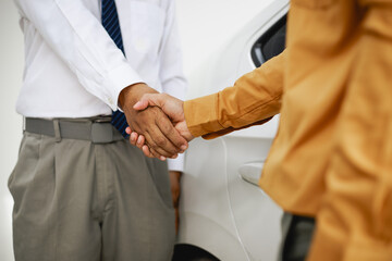 Obraz premium In a showroom, people engage in buying or leasing cars, working with salespeople to finalize contractsDiscussions involve choices agreements financingThe process includes paperwork explaining terms