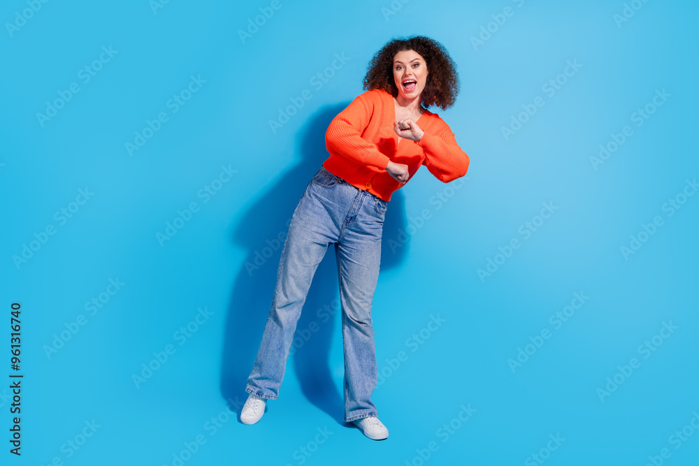 Wall mural photo portrait of young latin funny lady with curly hairstyle in orange cardigan dancing night club 