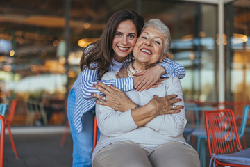 Smiling Grandmother and Granddaughter Hugging at a Cafe