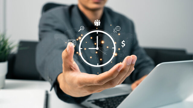Time management concept. Work planning increases efficiency and reduced work time.  businessman holding clock and money icon on interface virtual for business time management.
